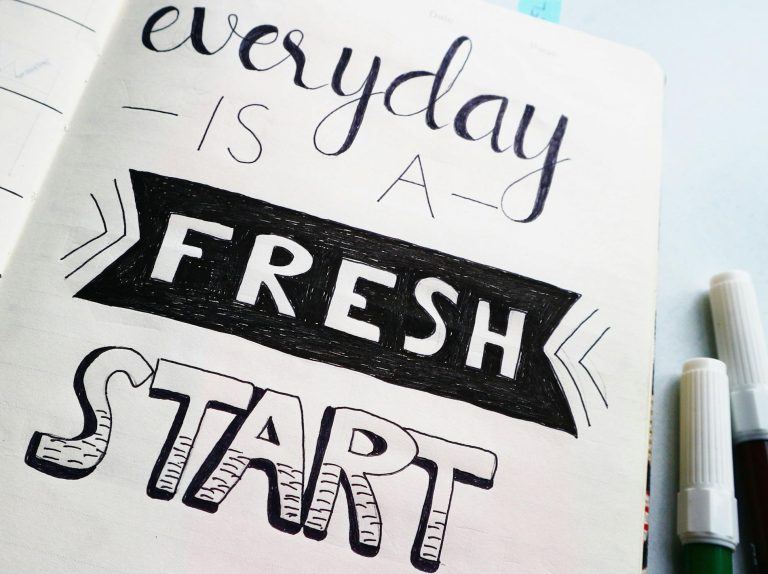 Notebook page featuring motivational quote 'Everyday is a fresh start' with colorful pens.