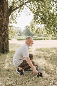 Senior man setting up yoga mat outdoors, promoting healthy lifestyle.