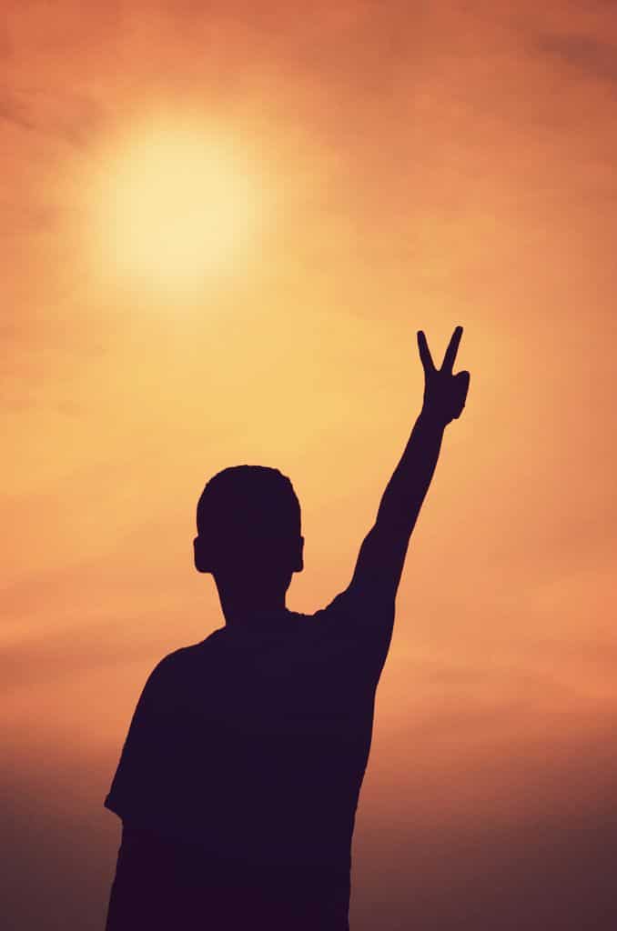 Person making a peace sign while protecting their peace and prioritizing mental wellbeing